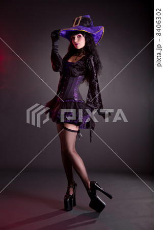 Pretty witch in purple and black gothic Halloween costume 8406302