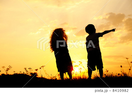 Silhouette, group of happy children playing on meadow, sunset, summertime 8410982