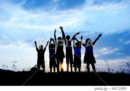 Silhouette, group of happy children playing on meadow, sunset, summertime 8411095