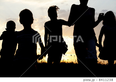Silhouette, group of happy children playing on meadow, sunset, summertime 8411238