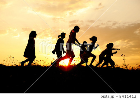 Silhouette, group of happy children playing on meadow, sunset, summertime 8411412