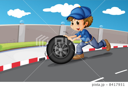 A boy pushing a wheel along the road A boy pushing a wheel along the road 8417931