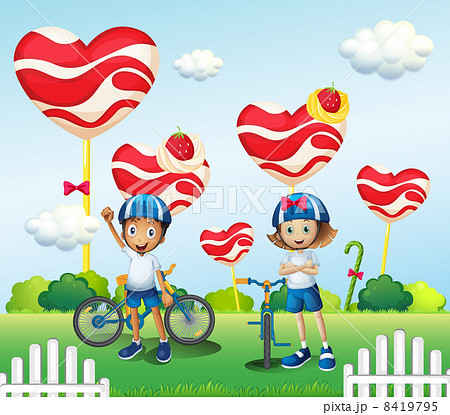 A boy and a girl biking near the giant lollipops A boy and a girl biking near the giant lollipops 8419795