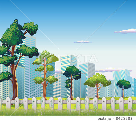 Trees inside the fence near the tall buildings 8425283