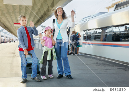 Mother with two kids and luggage stands on platform, all three w 8431850