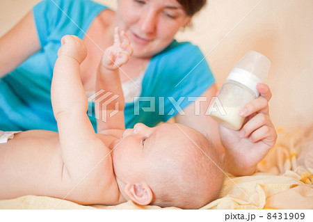 Mom feed baby with bottle, play in bed 8431909