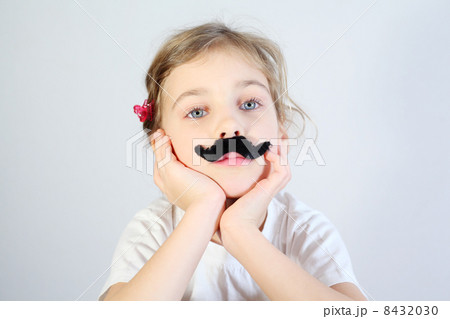 Little melancholy girl in white with glued fake black mustache. 8432030