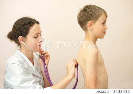 Doctor listens to lungs of little boy with stethoscope 8432450