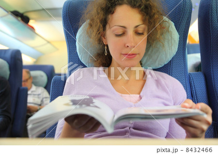 one young woman watching magazine in train 8432466