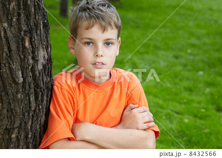 Portrait of boy in orange t-shirt, standing with folded arms in 8432566