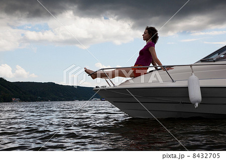 Woman meditate on bow of cutter in evening, side 8432705