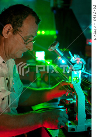 Scientist engaged in research in his lab show movement of microparticles by laser 8432762