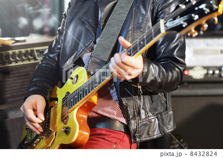 Young man plays electric guitar in studio 8432824