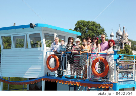 Big family of nine people walking on pleasure craft near cathedral 8432954
