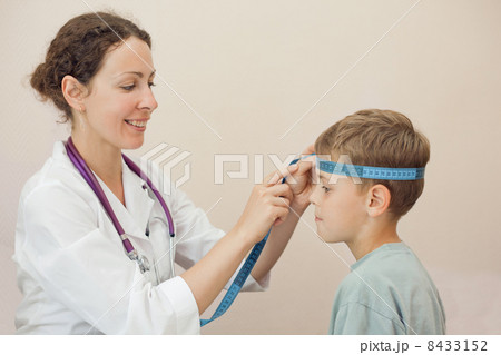 Doctor measures volume of head boy with tape 8433152