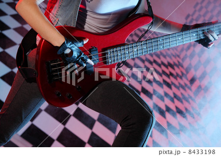 Part of body of woman playing electric guitar in studio with che 8433198