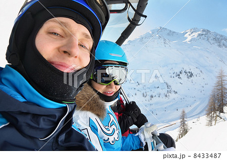 Male and female skiers in special clothing ride on cable car in 8433487