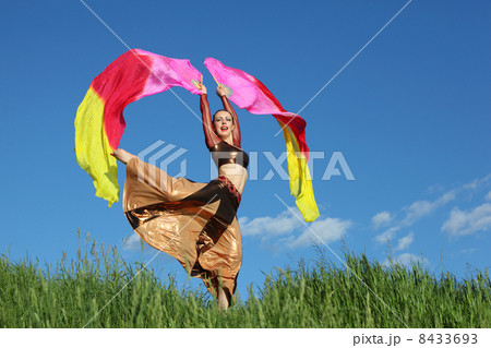 Singing woman wearing beautiful suit dances with pink veil fans 8433693