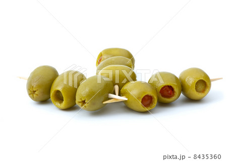 Some olives stuffed with pepper on a wooden toothpicks Some olives stuffed with pepper on a wooden toothpicks 8435360