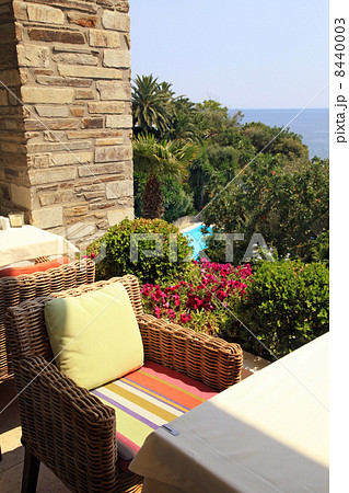 wicker armchair on terrace overlooking the sea and garden (Greec 8440003