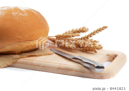 Fresh bread with ears and a knife of wheat on the wooden cutting Fresh bread with ears and a knife of wheat on the wooden cutting 8441821