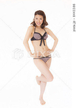ポーズをとるビキニの若い女性 8443386