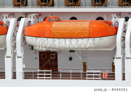 Orange lifeboat installed on large white passenger liner deck 8449161