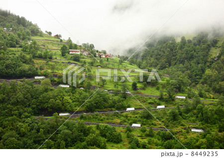 Cars ride by mountain road from coastal village to dwelling on t 8449235