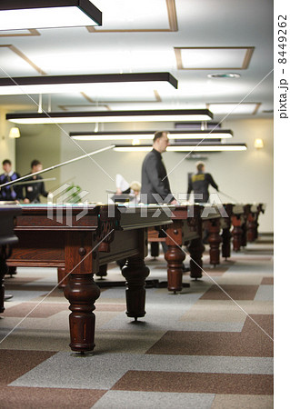 Four mens play in pool in billiard club, focus on table 8449262