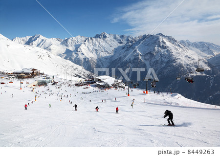 Cable car, buildings in mountains. Many skiers ride in Alps at s 8449263