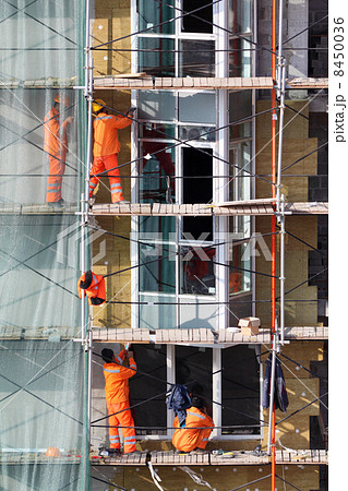 MOSCOW - OCTOBER 7: Men works on scaffolding of buildings of com 8450036