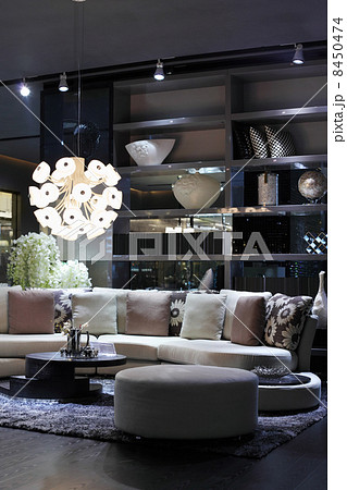 Stylish room with semicircular sofa, small round magazine table, 8450474