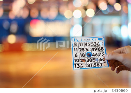Woman hand holds bingo card with holes at background of big boar 8450660