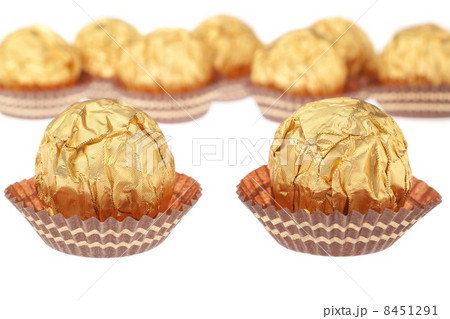 Group chocolate candies wrapped in gold. On a white background. 8451291