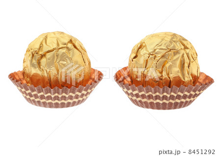Two chocolate candies wrapped in gold. On a white background. Two chocolate candies wrapped in gold. On a white background. 8451292