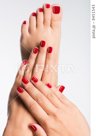 Closeup photo of a female feet with beautiful red pedicure 8451543