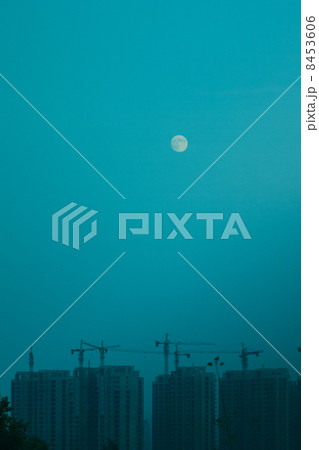 夕方の月と建築現場 8453606