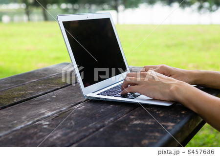 Typing on Laptop on Bench 8457686