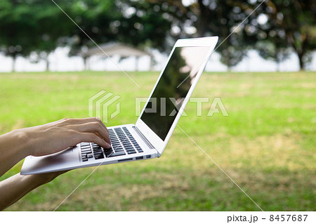 Laptop on hand in park Laptop on hand in park 8457687
