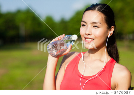 Asian Woman in Sportswear Listening to Music 8476087