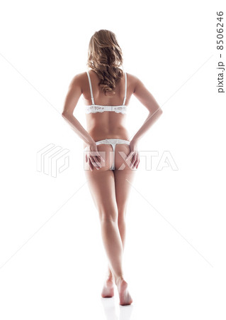 Slim model in white lingerie posing back to camera Slim model in white lingerie posing back to camera 8506246