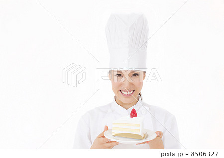 ショートケーキを持つパティシエの写真素材