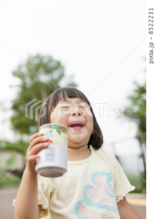 缶ジュースを飲む子の写真素材