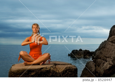 Beautiful young woman doing yoga exercise outdoors 8528447
