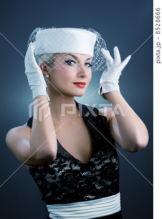 Beautiful young woman in white hat with net veil. Retro portrait 8528666