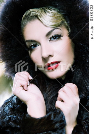 Beautiful woman in winter fur coat. Toned in blue 8530802
