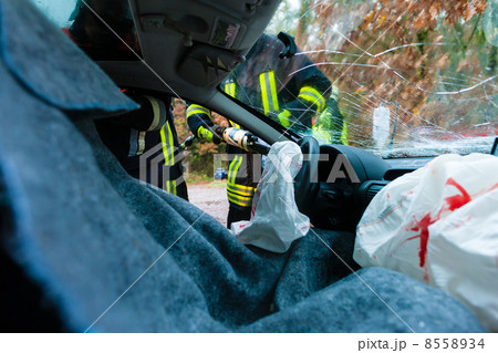 Car accident - Victims in crashed vehicle receiving first aid 8558934