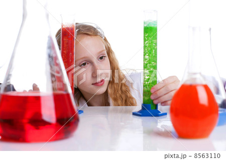 Lovely schoolgirl looking at flasks with chemicals 8563110