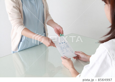 受付で薬の説明をする薬剤師 8564997