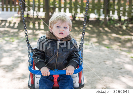 Beautiful toddler boy having fun on swing Beautiful toddler boy having fun on swing 8566642